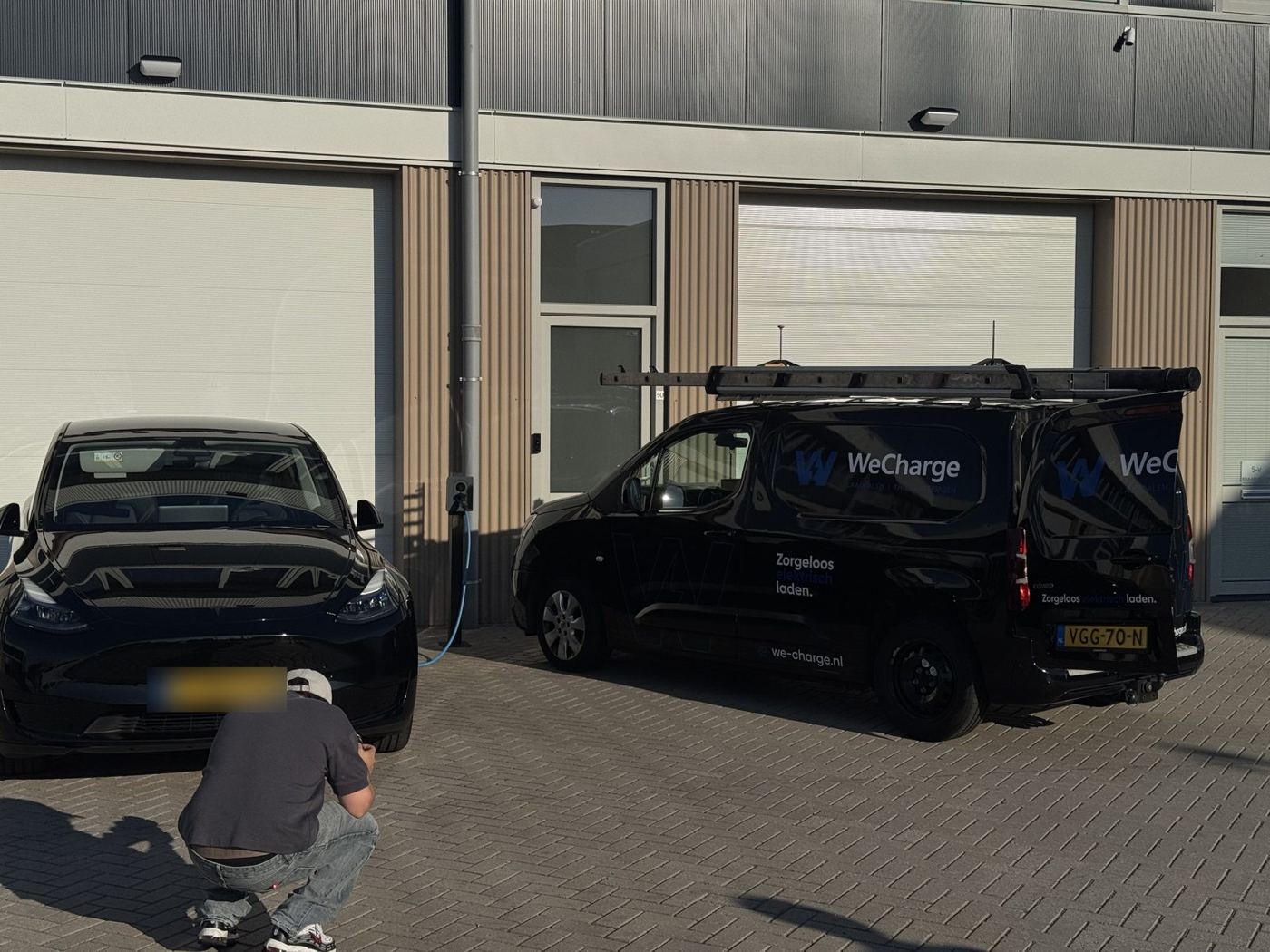 Opname bij WeCharge: de camera laag bij een ladende auto naast de WeCharge-bus